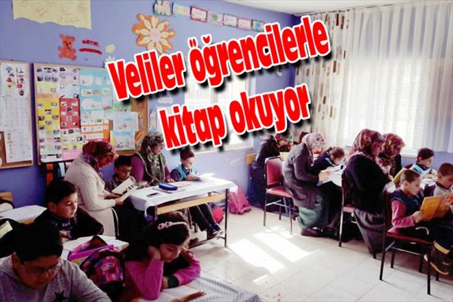 Veliler öğrencilerle kitap okuyor