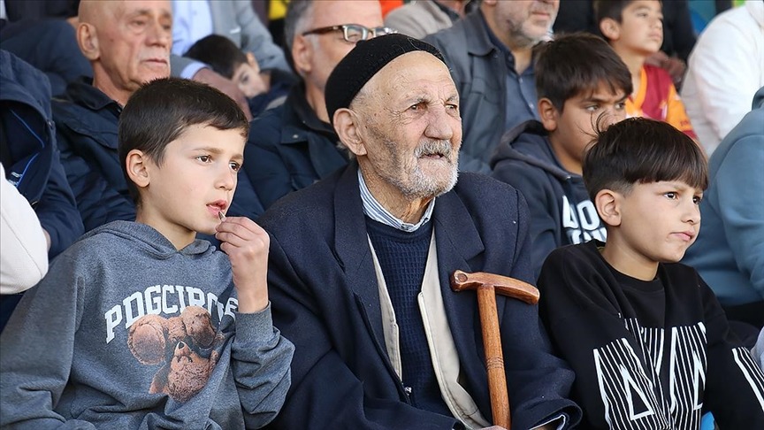 Kolunda torunları elinde bastonu maç maç geziyor
