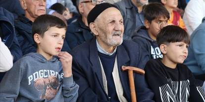 Kolunda torunları elinde bastonu maç maç geziyor