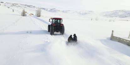 Kar yağışını fırsata çevirdiler, traktörün arkasında kayarak eğlendiler